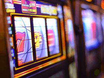 Close-up of a slot machine with colorful lights and spinning reels in a casino